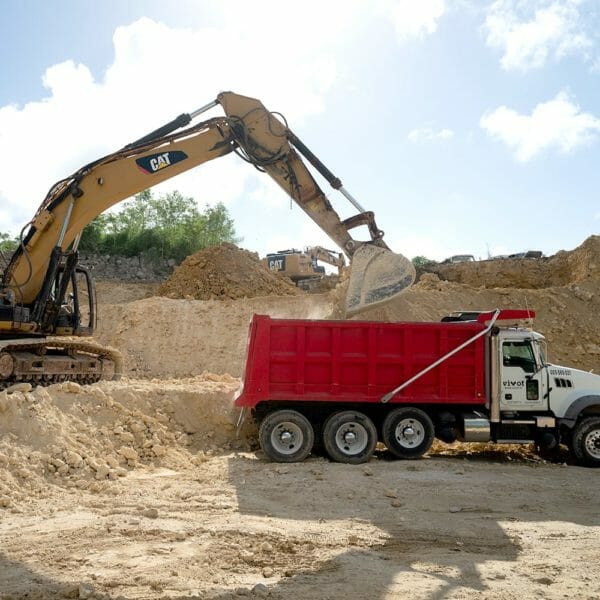 crane lifting dirt into a truck