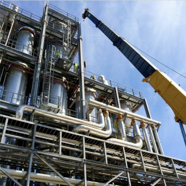 crane lifting above a complex structure of metal tubes